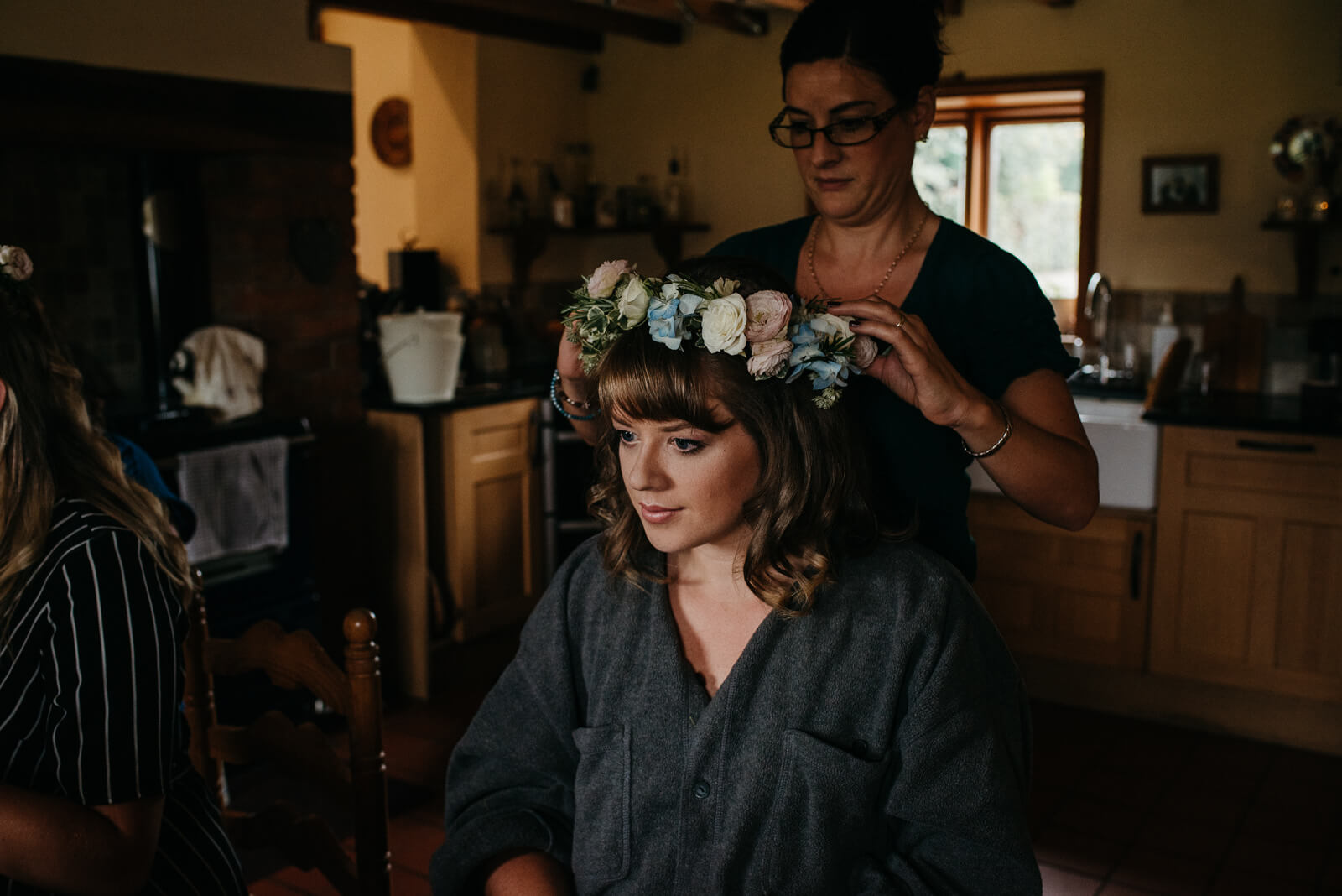 Moody candid of bride during prep gettign ready with her pastel floral crown at her Shropshire home