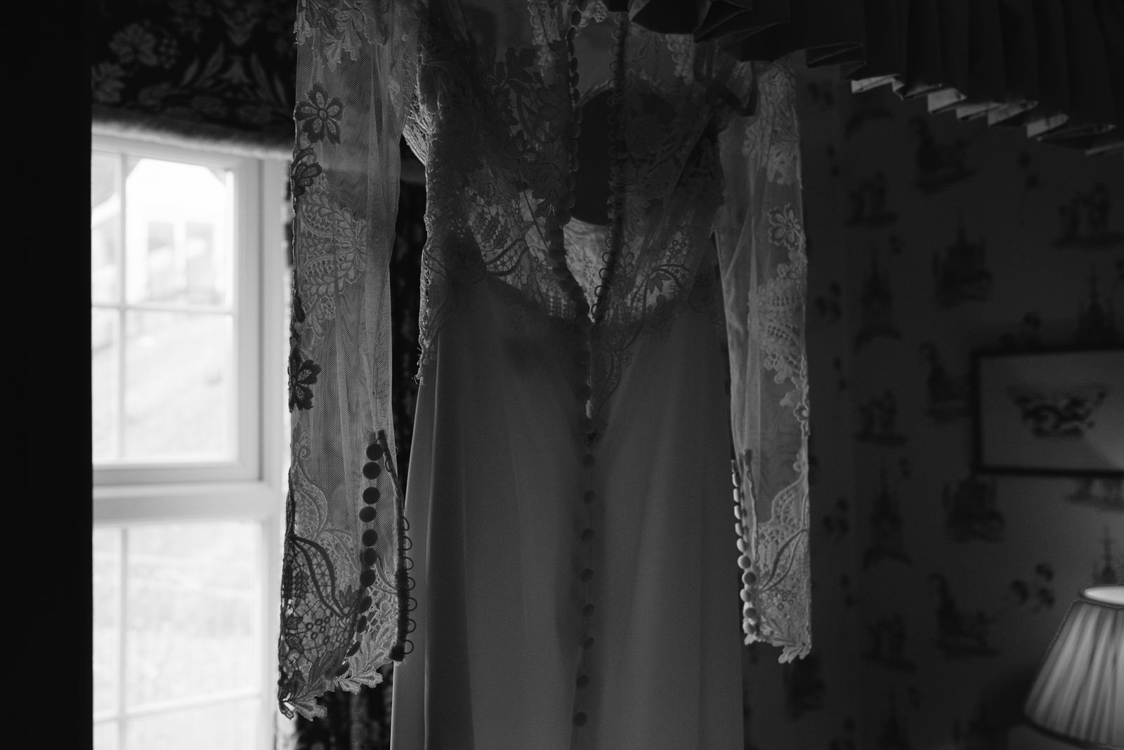 fine art photograph of brides lace wedding dress hanging in New House Hotel in Lisvane