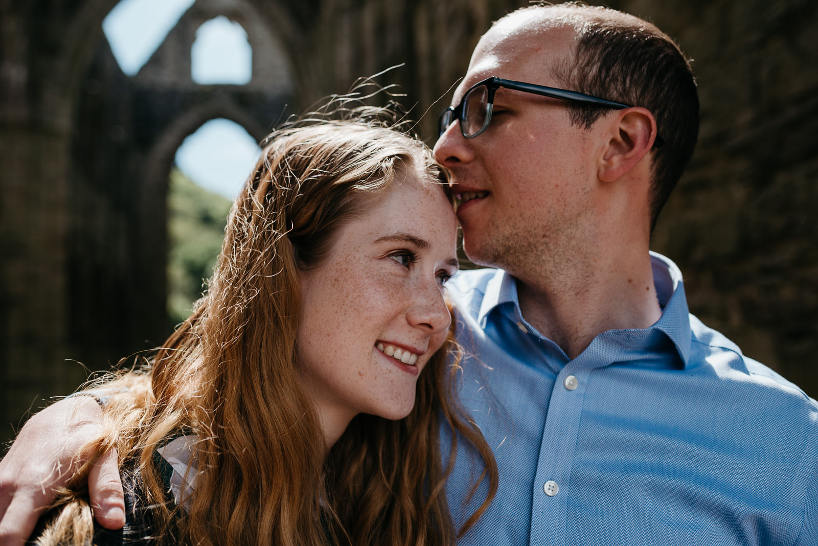 Groom tenderly kissing his bride during Tintern Abbey couple shoot