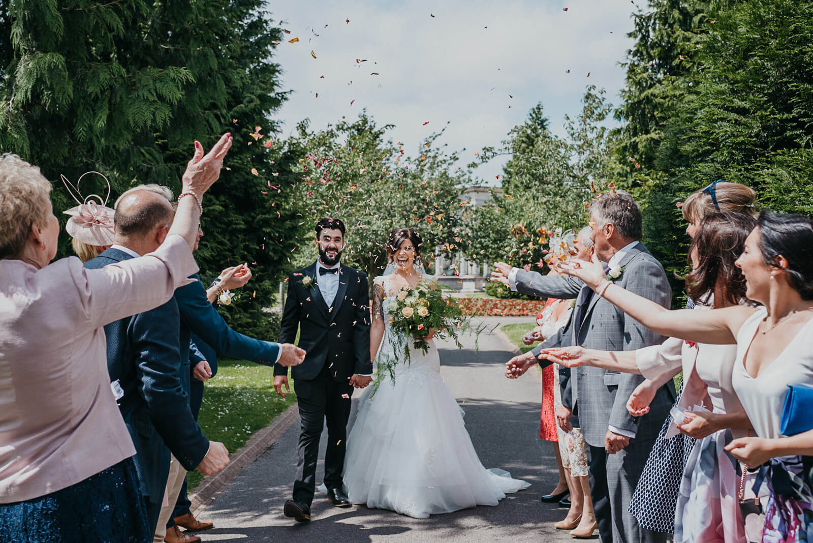 bride and groom walk though confetti after their city hall registry office wedding in cardiff