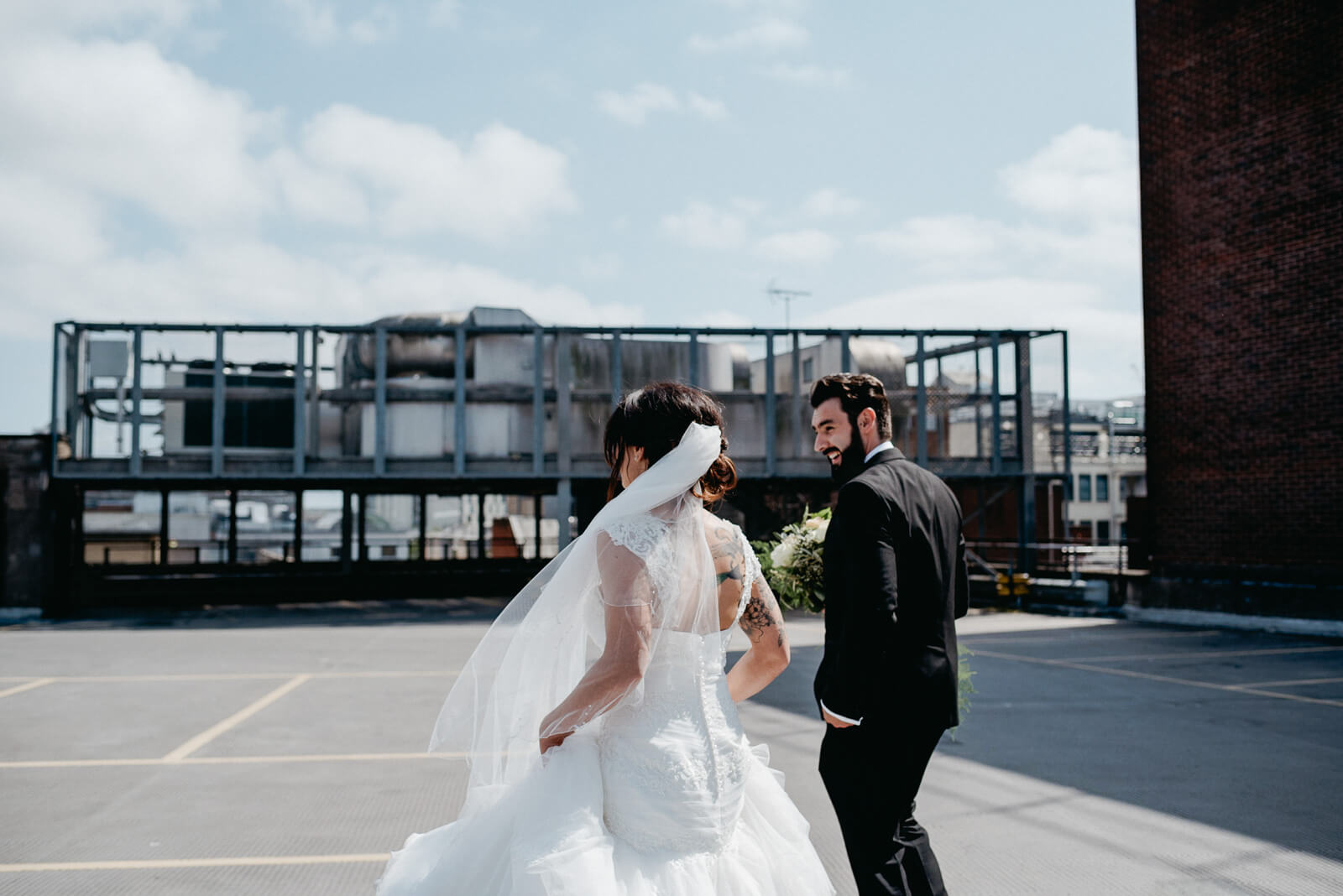 alternative bride and groom on rooftop of car park in the heart of the city