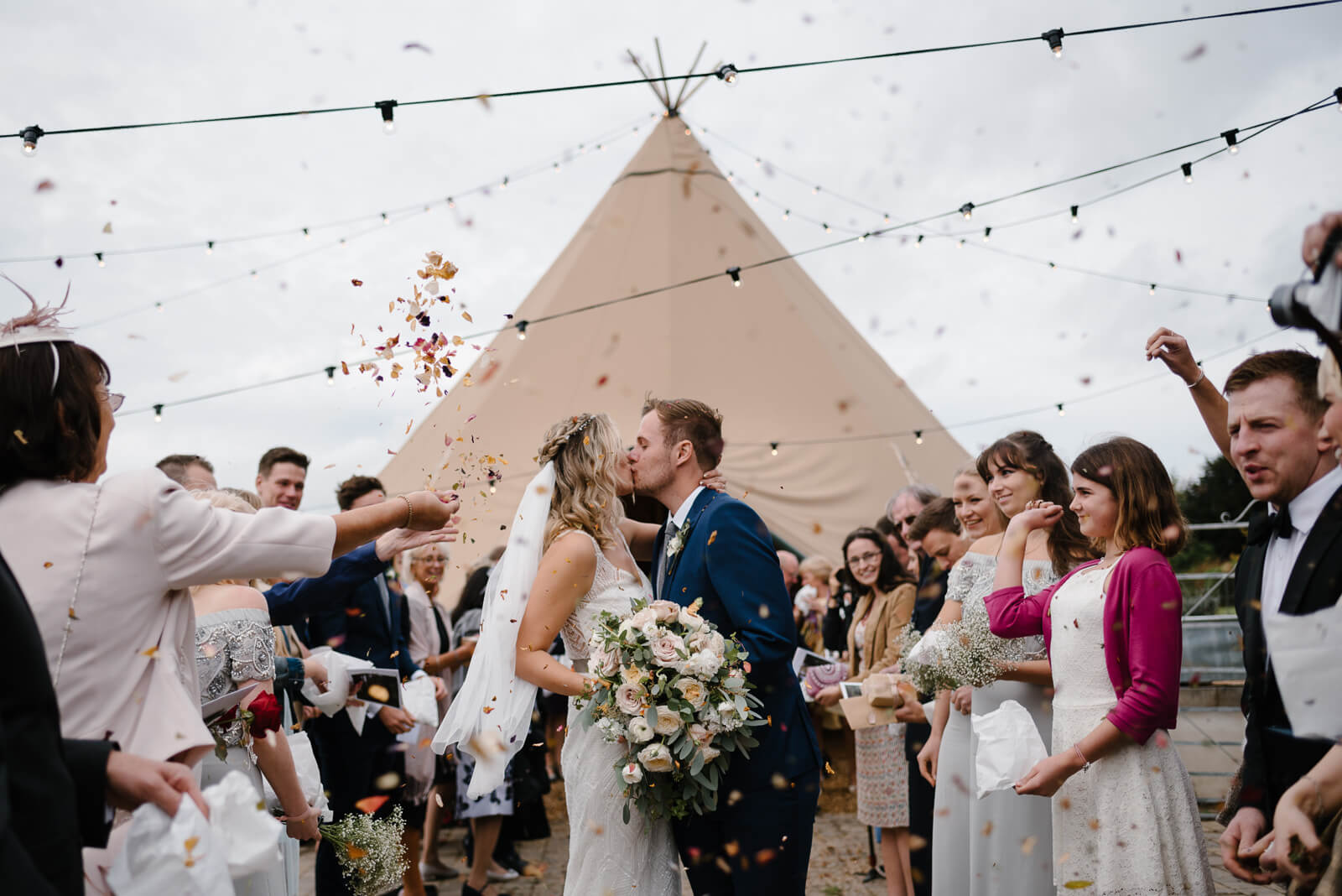 bride and room kiss under confetti at Glove Factory studios wedding in Holt