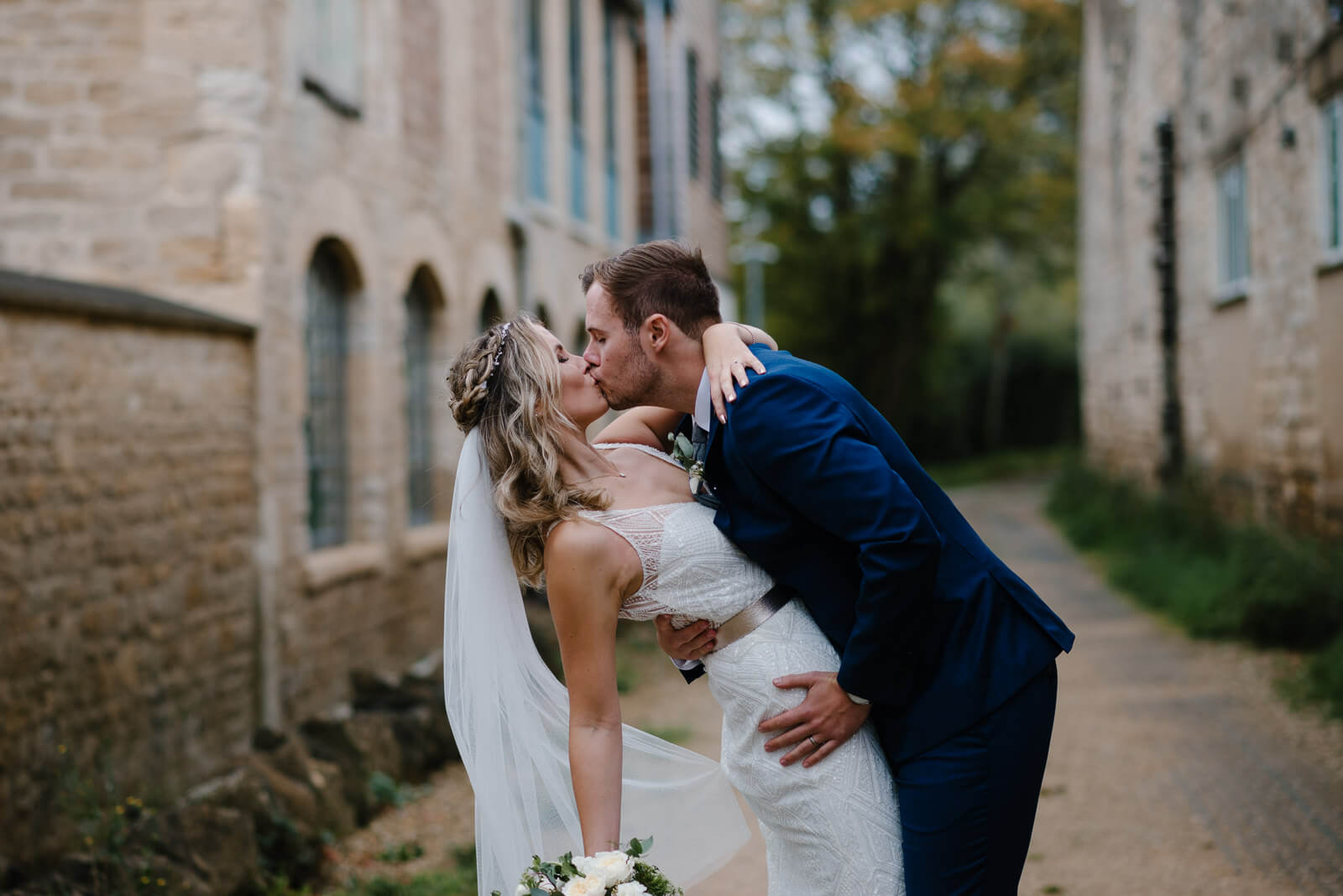 groom kisses bride when taking some time out from their rustic Wiltshire wedding