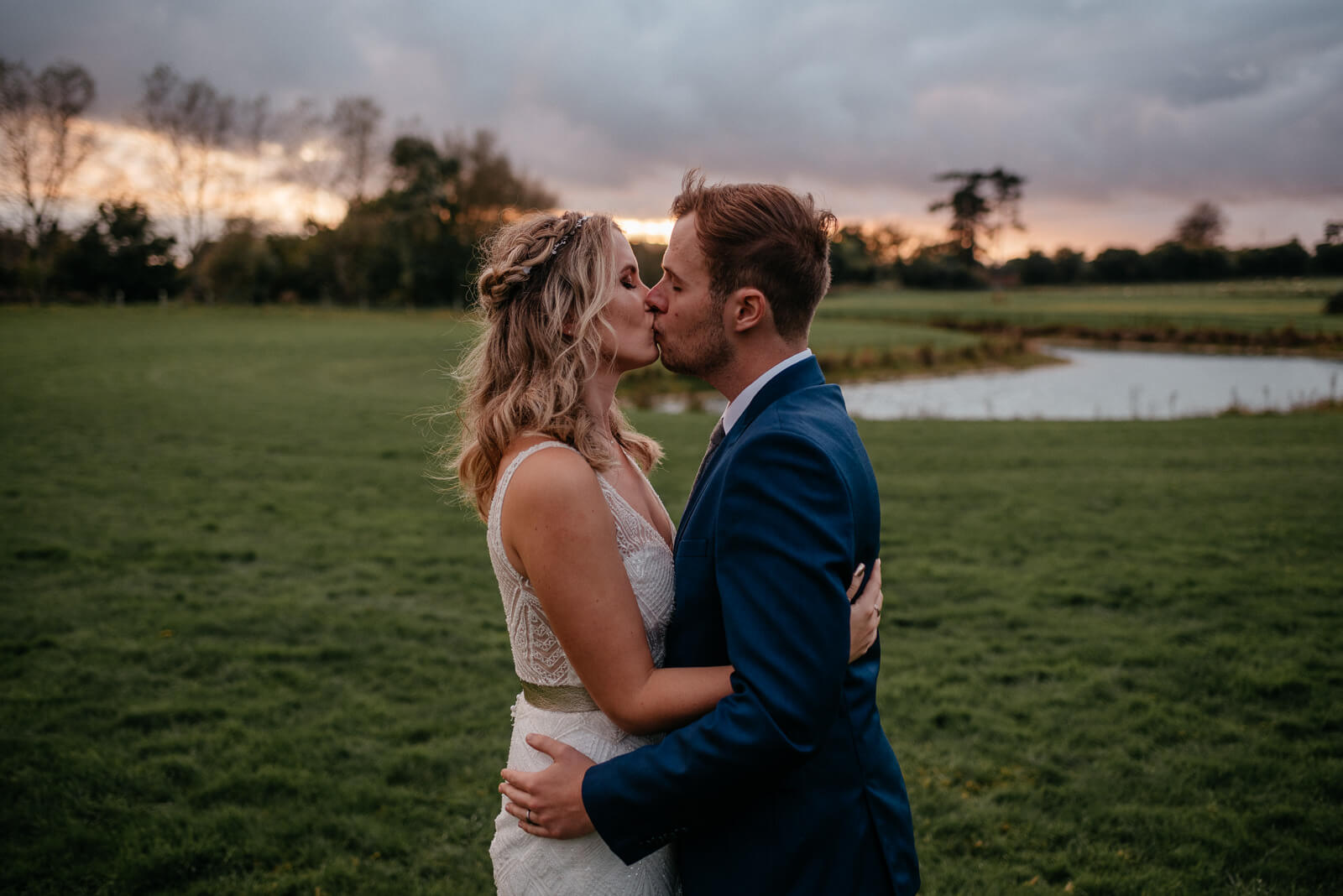 bride and groom kiss at sunset at Glove Factory Studios in Holt