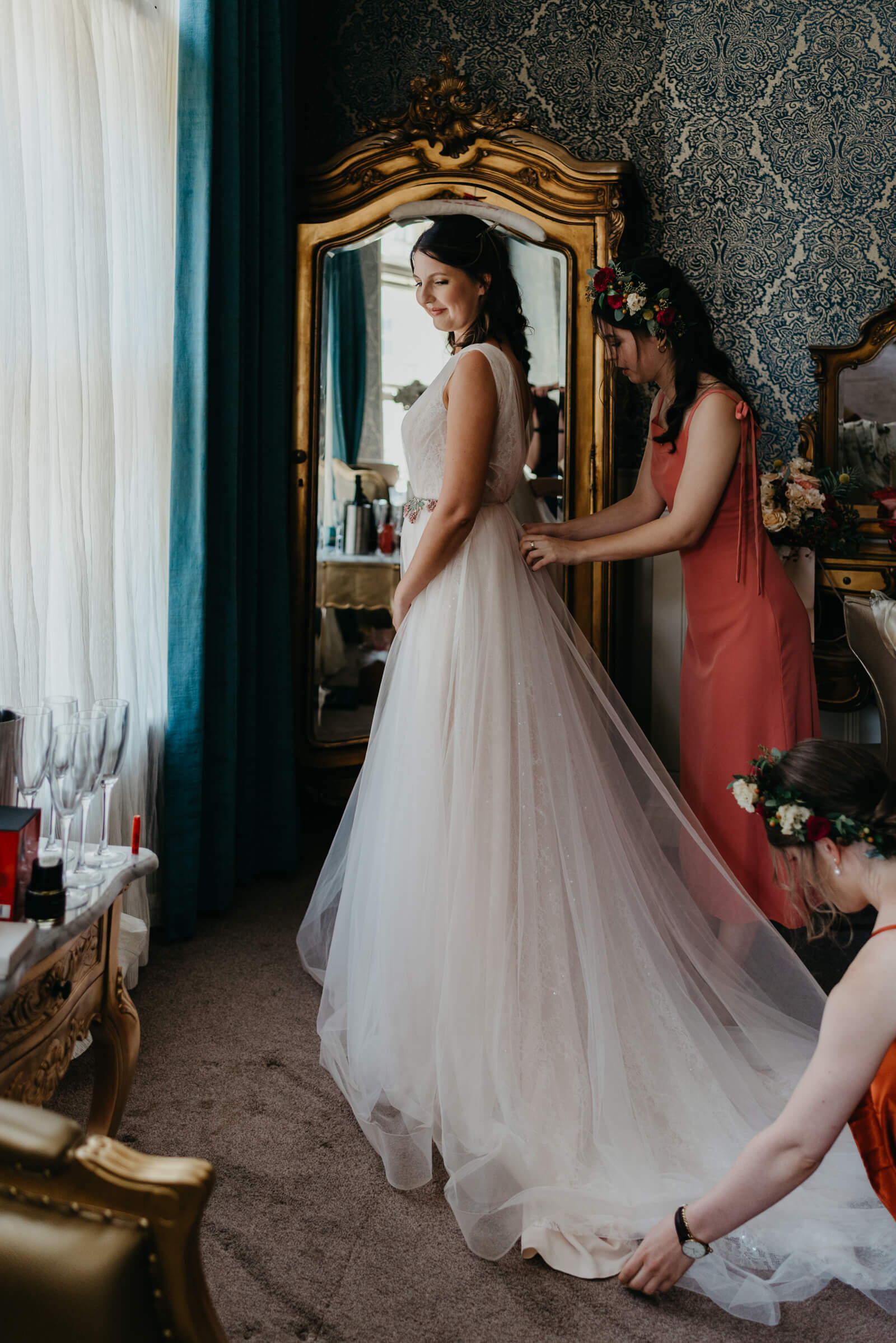 maid of honour fastens brides dressing before wedding
