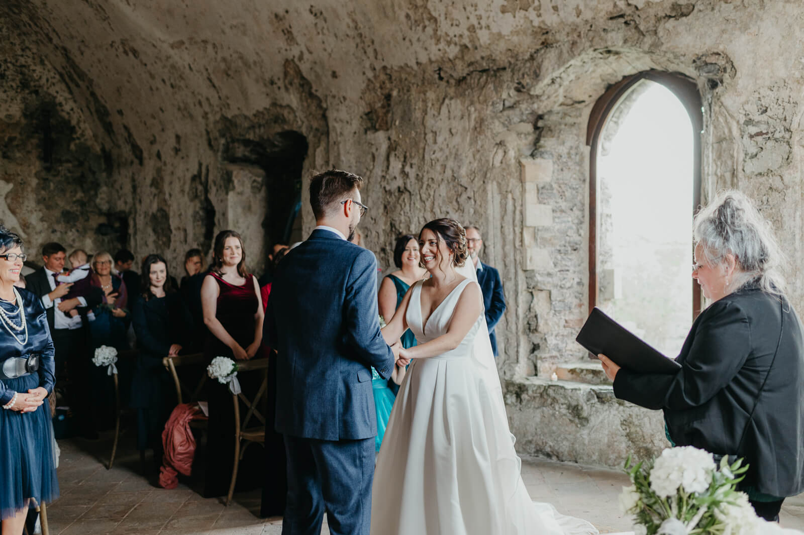bride and groom exchange vows in wedding chapel at Manorbier Castle