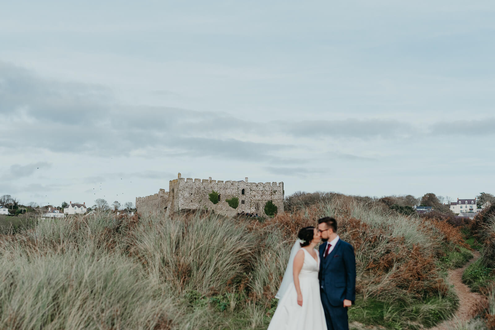 bride and groom with Manorbier Beach in background